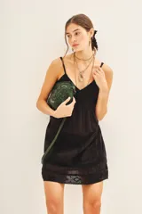 Vestido corto negro de algodón con puntillas y bordados a tono, corte amplio, ajuste en el bajo busto y breteles regulables.