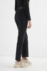 Pantalón jean negro cropped, de corte acampanado y tiro alto.