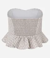 Top strapless color blanco roto con escote corazón y peplum fruncido en el bajo. El tejido presenta una textura acolchada o capitoneada.