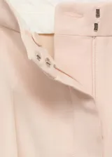 Pantalón de vestir color beige, de corte recto, con bolsillos laterales y cierre frontal con botón, gancho y cremallera oculta.