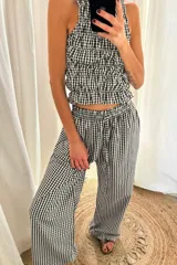 Pantalón ancho de tiro alto, con cordón ajustable en la cintura y estampado de cuadros vichy en blanco y negro.