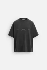 Camiseta negra de corte relaxed fit, cuello redondo y manga corta. Estampado frontal con texto en relieve a contraste. Efecto lavado.