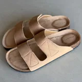 Sandalias bajas color beige con doble tira ancha sobre el empeine y plantilla anatómica.