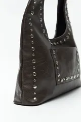 Cartera negra tipo hobo de cuero sintético con apliques de tachas metálicas plateadas en el frente y los bordes.