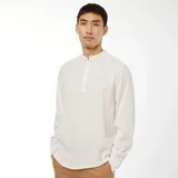 Camisa blanca de manga larga con cuello mao y textura gofrada.