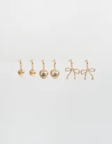 Set de tres pares de aros dorados tipo argolla con dijes colgantes: un par con dijes de corazón liso, un par con dijes de corazón con estampado floral vintage y un par con dijes de moño.