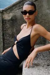 Vestido midi negro de punto con escote pico, tirantes finos cruzados en la espalda, aplique dorado y abertura en la cintura.