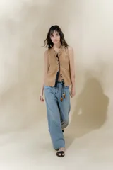 Chaleco color beige confeccionado en lino, con cuello mao, volados en la parte delantera y cierre con botones forrados.