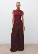 Camiseta sin mangas color borgoña, de tejido elástico y diseño entallado, con cuello redondo y tirantes anchos.