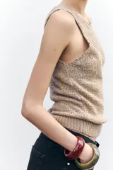 Top color beige de punto rústico con cuello redondo y sisa.