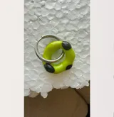 Aro de acero con dije colgante de cristal de Murano color verde lima con manchas negras.