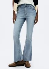 Pantalón de jean azul, modelo petit flare, tiro alto y corte ajustado en la cadera y muslos, con pierna acampanada desde la rodilla.