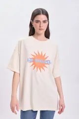 Remera manga corta oversize color crudo con estampa de sol y texto 'Le Soleil' en naranja y celeste.