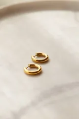 Par de aros tipo argolla gruesos de acero quirúrgico hipoalergénico color plateado.