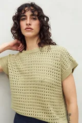 Chaleco tejido color verde claro con diseño calado, cuello redondo y mangas cortas. De silueta relajada y tejido con transparencias.