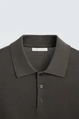 Polo azul marino de punto ligero tejido en hilatura con mezcla de seda y algodón. Cuello solapa con cierre frontal de botonadura, manga larga y acabados en rib.