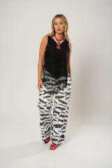 Pantalón palazzo blanco con estampado de peces negros.