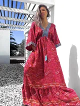 Vestido largo tipo túnica con estampado paisley en tonos rojos y detalles bordados en azul en escote y mangas.