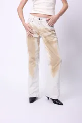 Pantalón de jean blanco con manchas marrones, de corte recto y tiro medio.