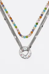 Collar de múltiples cadenas con acabado metálico plateado. Presenta una hilera de cristales multicolores y varias cadenas finas que convergen en un dije circular central con un calado en forma de corazón y la palabra 'LOVE' grabada. Posee cierre de mosquetón.