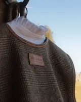 Chaleco marrón con diseño a cuadros y borde de cuero.