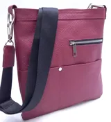 Morral de cuero color bordó con textura granulada. Posee correa ajustable de tela negra para usar como bandolera o morral, cierre superior metálico y un bolsillo exterior con cierre y otro abierto con broche metálico.