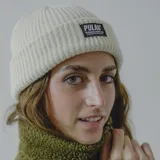 Gorro de lana blanco con etiqueta negra con el logo de la marca Pulau.