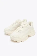 Zapatillas deportivas color crema con suela chunky y plataforma irregular de 5 cm.