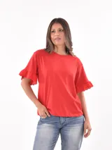 Remera roja de mangas cortas con volados de encaje en los puños y cuello redondo. Corte clásico.