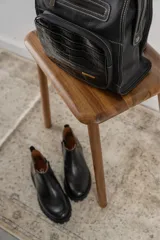 Botines negros de cuero con elástico lateral, detalle charol en el talón y suela track.