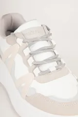 Zapatilla con diseño único y recortes irregulares en tonalidades beige y naranja, con plataforma de 4 cm.