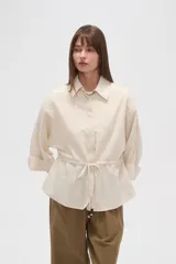 Chaqueta color beige de viscosa con botones, cuello camisero y cordón ajustable en la cintura.