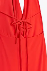 Vestido largo rojo de cuello halter con escote drapeado y espalda descubierta.