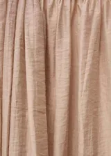 Vestido largo color rosa pálido, sin mangas, con cuello redondo fruncido y falda evasé. Confeccionado en tejido mezcla lyocell con bajo abullonado y cierre de botón en el cuello.