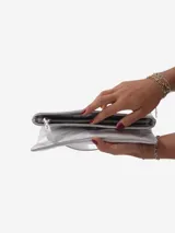 Sobre de fiesta negro charolado con cierre de solapa imantada y tira de cuero para sujetar a la muñeca.