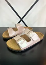 Sandalias de dedo color rosa con hebillas plateadas y plantilla de corcho.