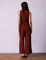 Mono enterito color ladrillo, marca June & Hudson, de crepe con escote en V, sin mangas, con detalle de botones en la cintura y cierre invisible en la espalda.