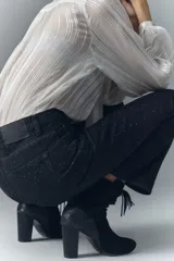 Pantalón de jean negro con corte recto y detalles brillantes.