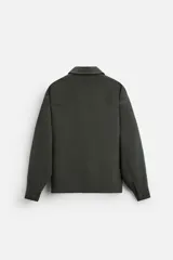 Sobrecamisa verde oscuro de corte cuadrado, con cuello solapa, manga larga con puños abotonados, bolsillos de parche en el pecho y bolsillos laterales en la cadera. Cierre frontal con botones.