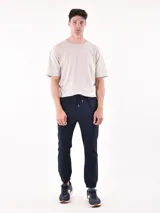 Pantalón jogger gris oscuro con cintura elástica ajustable con cordón y puños elásticos en los tobillos.