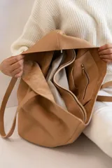 Tote negra amplia de cuero vacuno, diseñada para la mujer moderna, con bolso separador extraíble para mayor organización.