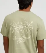 Remera de hombre color verde salvia, confeccionada en algodón peruano, con cuello redondo, manga corta y un pequeño bordado de lettering y palmeras en el pecho.