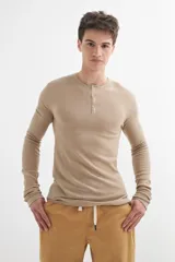 Sweater de acrílico color beige, de manga larga y cuello redondo con botones.