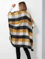 Ruana de tejido soft, color rosa pálido, celeste, gris y beige, con diseño a cuadros. Presenta terminación en zig zag con lana en los bordes y sisa amplia.