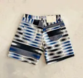 Bermuda de denim con estampado de círculos concéntricos en tonos azul, gris y blanco.