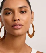 Aros maxi triples con textura de serpiente, color dorado, confeccionados en metal reciclado y cierre de tornillo.