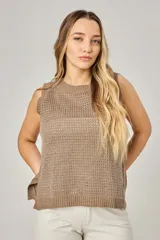 Chaleco de punto calado color blanco, con cuello redondo y sisas anchas.