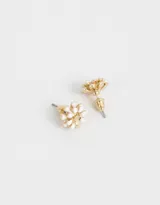 Par de aros pasantes con forma de flor esmaltada blanca con centro dorado y cierre de tope a presión.