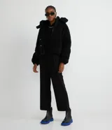 Campera puffer de sherpa color negro, con capucha, cierre frontal y regulador elástico en la cintura.