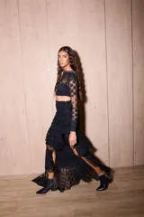 Top negro de manga larga, corte cropped y cuello alto, confeccionado en encaje con patrón geométrico. El cuello tiene un detalle de pedrería o brillo.